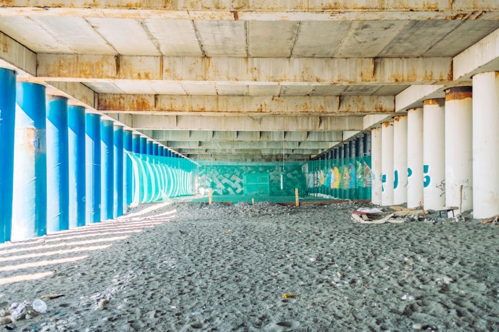 Explore the vibrant colors and textures of an industrial underpass in Sochi, Russia, showcasing graffiti art.